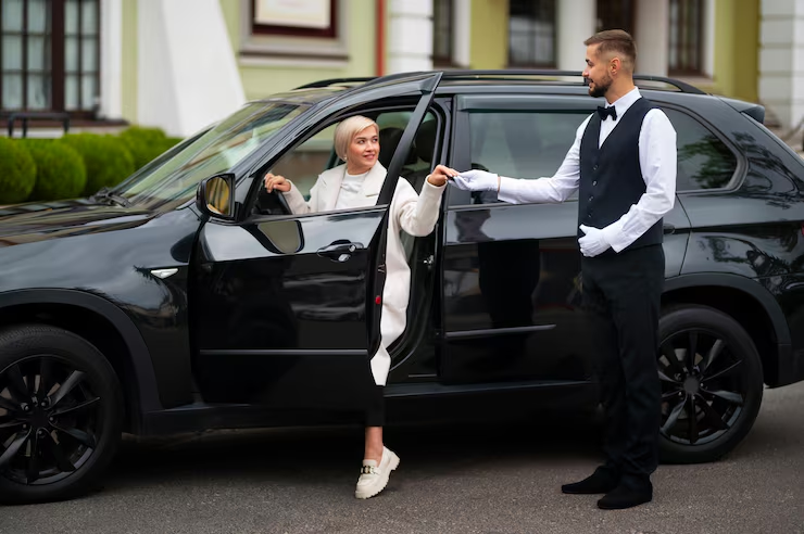 Chauffeur helping a lady out of a car